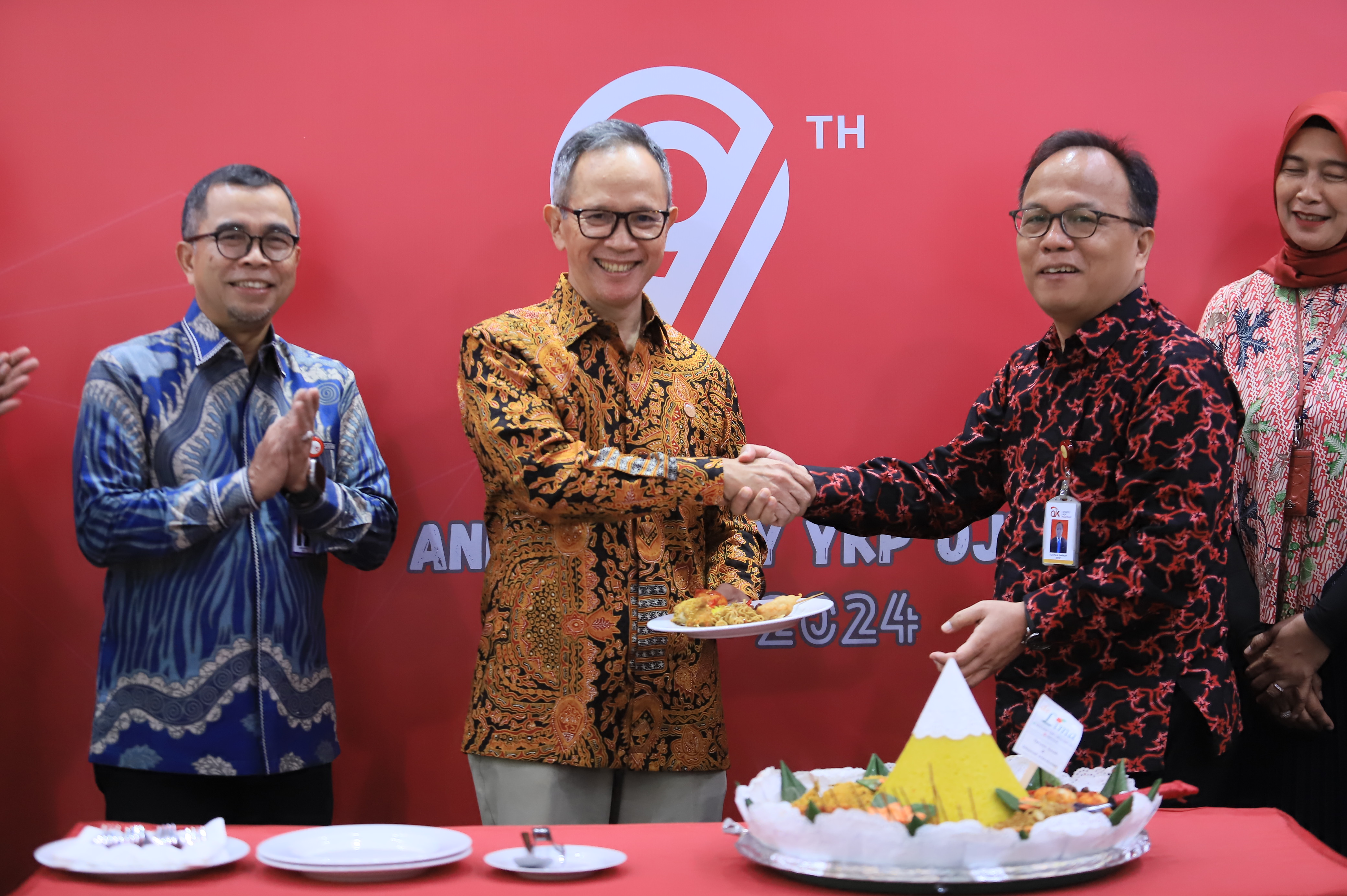 Penyerahan Potongan Tumpeng kepada Ketua Dewan Komisioner OJK dalam HUT YKP OJK Ke-9
